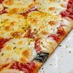 Thin New York-style pizza slice with golden crust and melted mozzarella