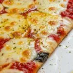 Thin New York-style pizza slice with golden crust and melted mozzarella