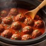 tender Italian meatballs simmering in marinara sauce in slow cooker
