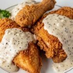 Crispy Southern chicken fried chicken topped with creamy pepper gravy on a plate