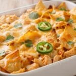 Nacho cheese chicken casserole baked with tortilla chips and melted cheese in a casserole dish