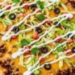 Sheet pan taco pizza with seasoned ground beef, melted cheese, and crispy golden crust