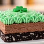 Layered Shamrock Lasagna dessert showing Oreo crust, chocolate cheesecake layer, and mint topping