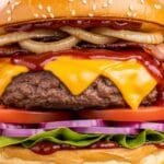 Juicy BBQ cheeseburger with melted cheddar cheese and fresh toppings on toasted bun