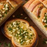Homemade garlic bread baked until crispy on the edges with a buttery garlic and parsley topping on a crusty loaf