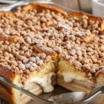 Overnight cream cheese French toast bake with custard-soaked bread and golden cinnamon crumb topping in a 9x13 baking dish