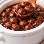 Crockpot grape jelly meatballs coated in a sweet and savory sauce in a slow cooker.