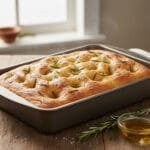 Easy Focaccia Bread Recipe: Simple Italian Flatbread Anyone Can Make Golden homemade focaccia bread with rosemary dimples baked in a rectangular pan