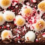 Close up of fudgy brownie with melted marshmallows and peppermint crumbs