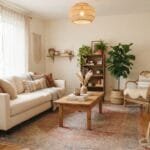 Cozy boho living room with a cream sofa, patterned rug, rattan chair, natural wood coffee table, houseplants, woven baskets, and warm earthy decor.