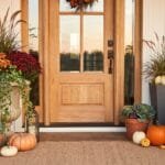 13 Fall Outdoor Planter Ideas for a Beautiful Seasonal Porch Fall porch decorated with outdoor planters filled with mums, ornamental cabbage, grasses, ivy, pumpkins, and terracotta pots.
